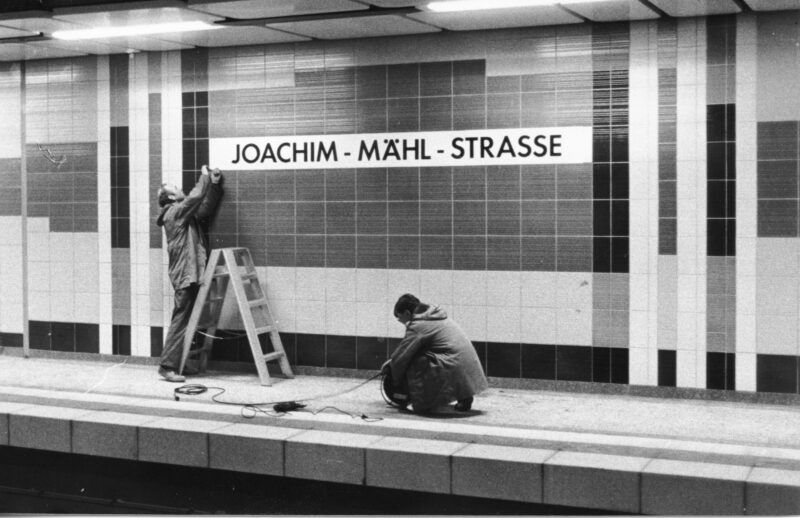 Zwei Männer mit den letzten Handgriffen an der Haltestelle Joachim-Mähl-Straße.